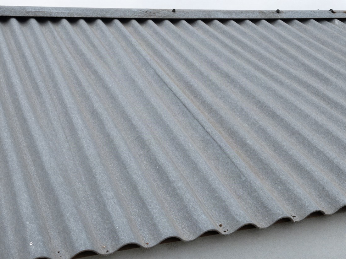 Weathered corrugated cement roof sheet on an older garage