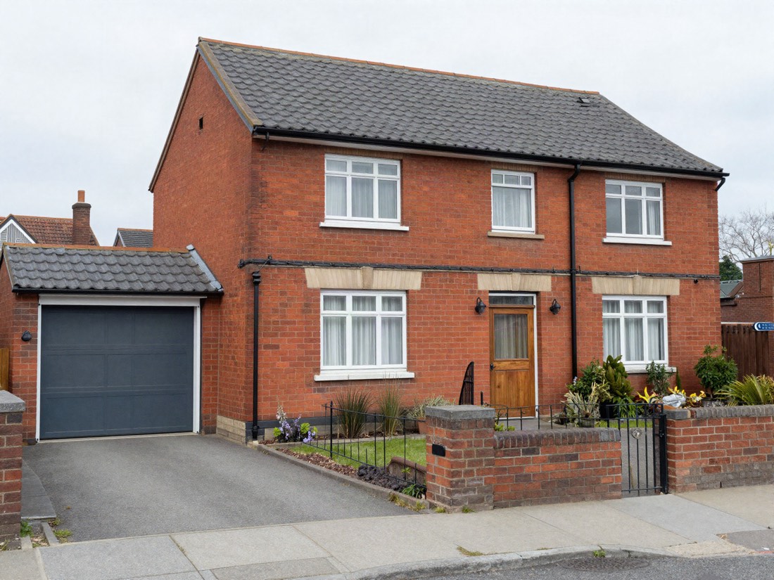 A 1960s British semi-detached house with an attached garage
